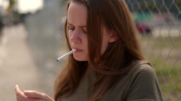 Jonge ontevreden vrouw steekt een sigaret op — Stockvideo