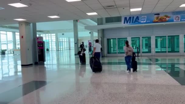 Podróżni na lotnisku Miami International Airport MIA - MIAMI, Stany Zjednoczone - LUTY 20, 2022 — Wideo stockowe