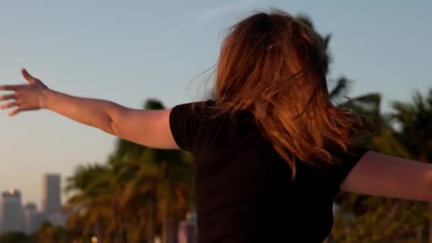 Счастливая женщина наслаждается прекрасным закатом на пляже Майами — стоковое видео