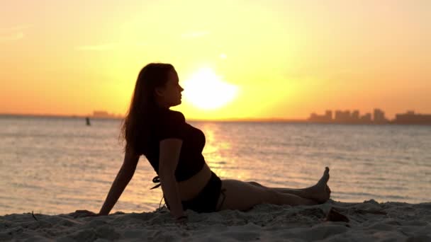 Kvinna slappnar av på stranden i Miami vid solnedgången - vacker siluett skott — Stockvideo