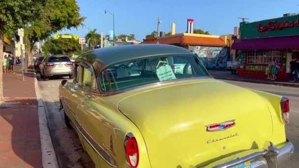 Oldtimer auto 's in Little Havana Calle Ocho - MIAMI, Verenigde Staten - FEBRUARI 20, 2022 — Stockvideo