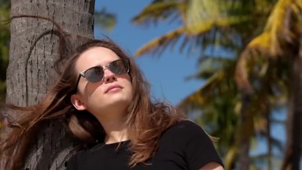 Ung kvinna kopplar av vid strandpromenaden i Miami Beach på en solig dag — Stockvideo