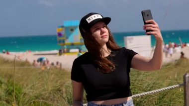 Miami Plajı 'ndaki güzel kadın sahilde selfie çekiyor.
