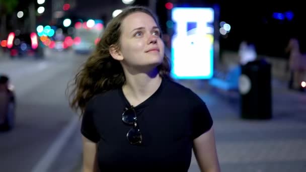 Девушка, идущая по улице ночью — стоковое видео
