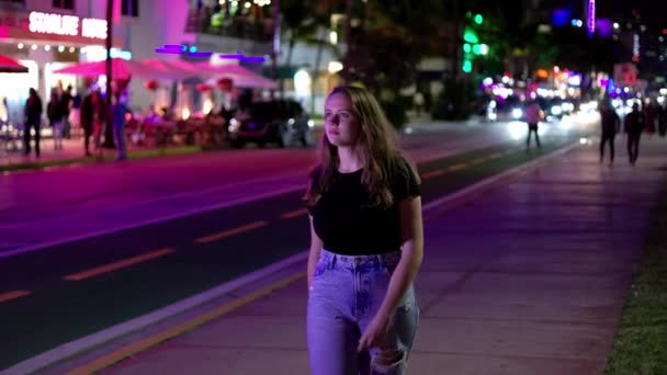 Kolorowe Ocean Drive w Miami Beach w nocy - młoda kobieta spacery wzdłuż ulicy — Wideo stockowe