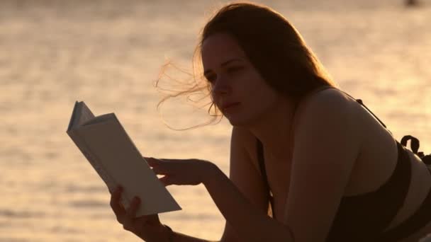 Silhouettenaufnahme einer schönen Frau bei Sonnenuntergang gegen das goldene Meerwasser — Stockvideo