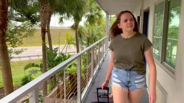 Mujer joven se registra en un motel — Vídeos de Stock