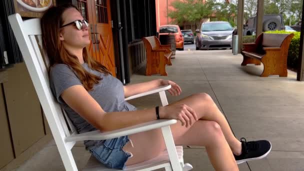 Wiejska dziewczyna relaksuje się w bujanym fotelu — Wideo stockowe