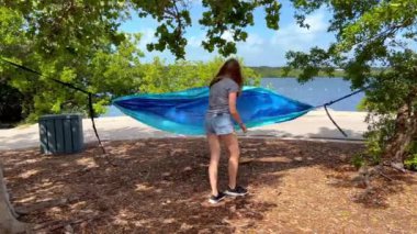 Genç bir kadın Florida 'da bir hamakta yatıyor.