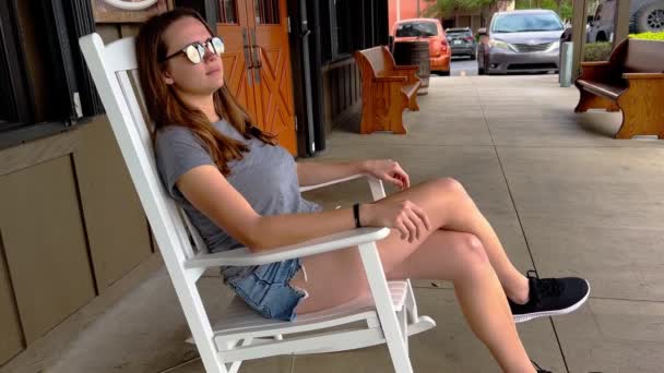 Κορίτσι της εξοχής χαλαρώνει σε μια καρέκλα Rocking — Αρχείο Βίντεο