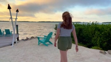 Genç bir kadın Florida Keys 'te sakin bir sahilde yürüyor.