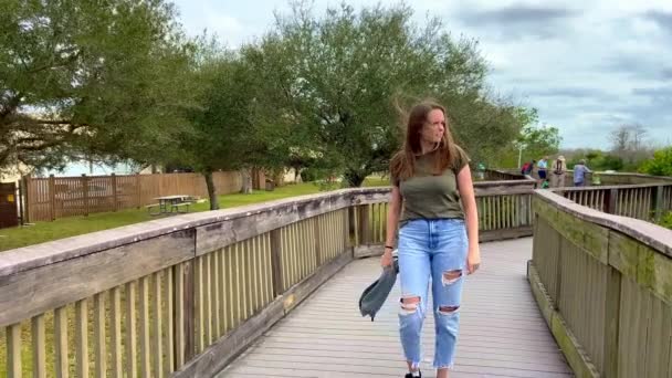 Jonge vrouw loopt over een steiger in de Everglades — Stockvideo