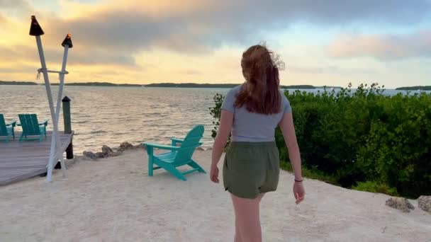 Ung kvinna går över en lugn strand i Florida Keys — Stockvideo