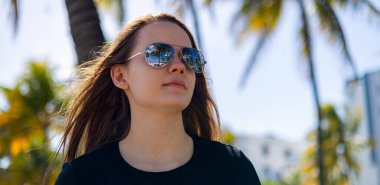 South Beach 'te palmiye ağaçlarının altında güzel bir kadın