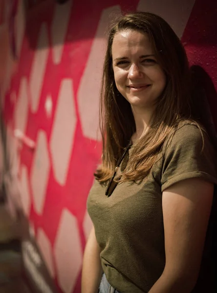 Retrato de uma menina bonita nas ruas contra uma parede colorida - fotografia de rua — Fotografia de Stock