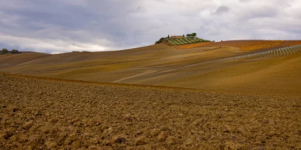 Typický pohled v Toskánsku - pestrobarevná venkovská pole a kopce — Stock fotografie