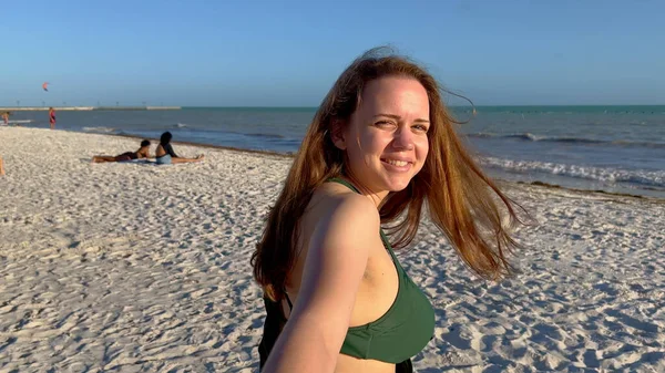 Молодая женщина тащит своего парня через пляж — стоковое фото