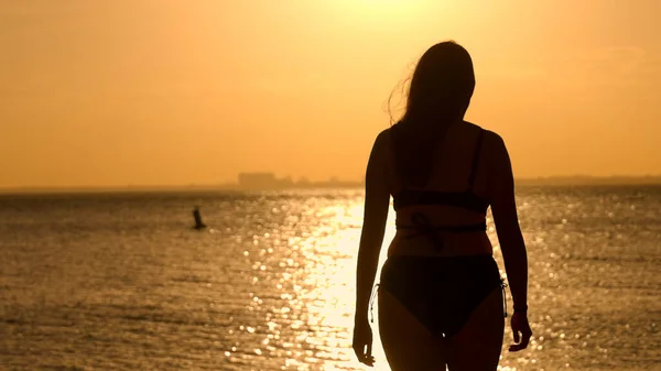 Mooie vrouw geniet van de warme oceaan water in Miami bij zonsondergang — Stockfoto