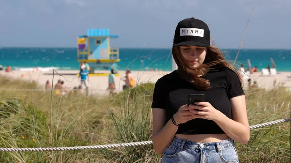 Mulher bonita em Miami Beach envia uma mensagem de texto — Fotografia de Stock