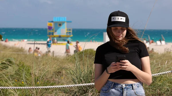 Mulher bonita em Miami Beach envia uma mensagem de texto — Fotografia de Stock