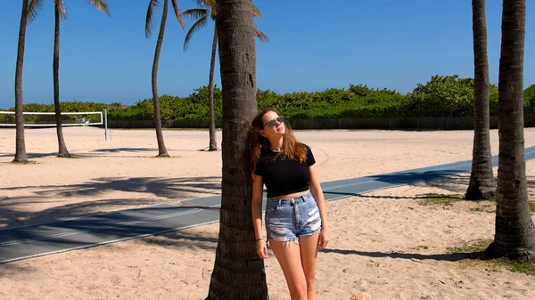 Junge Frau entspannt an der Strandpromenade von Miami Beach an einem sonnigen Tag — Stockfoto