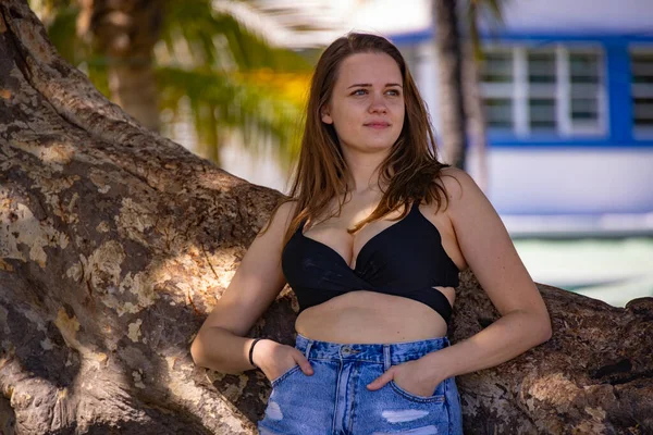 Mooie jonge vrouw poseren bij een palm boom op Miami Beach — Stockfoto