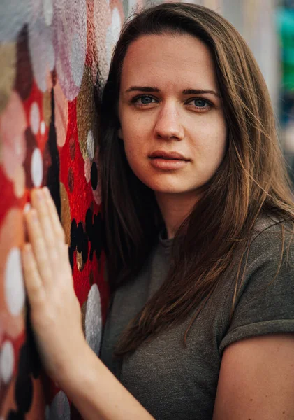Retrato de uma menina bonita nas ruas contra uma parede colorida - fotografia de rua — Fotografia de Stock