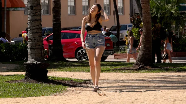 Junge Frau spaziert an einem sonnigen Tag am Miami Beach - MIAMI, FLORIDA - 14. FEBRUAR 2022 — Stockfoto
