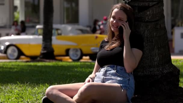 マイアミ・サウスビーチの遊歩道で太陽の下でリラックスした若い女性 — ストック動画