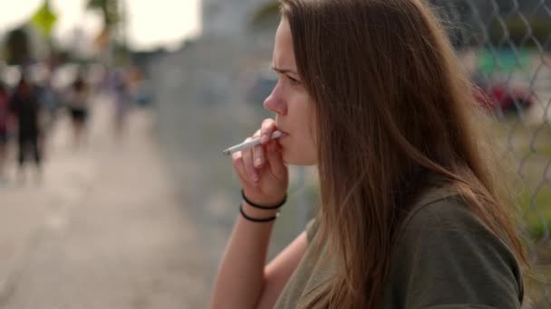 Young dissatisfied woman lights a cigarette — Stock Video