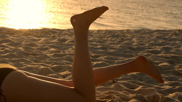Relaxando na praia ao pôr do sol desfrutando dos raios de sol quentes sobre o oceano — Fotografia de Stock
