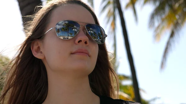 Nahaufnahme eines hübschen Mädchens unter Palmen am Strand — Stockfoto