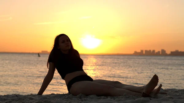 Donna si rilassa sulla spiaggia di Miami al tramonto - bella silhouette girato — Foto Stock