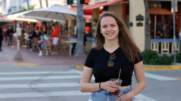 Jovem mulher bonita tem uma bebida fria ao sol de Miami Beach — Fotografia de Stock