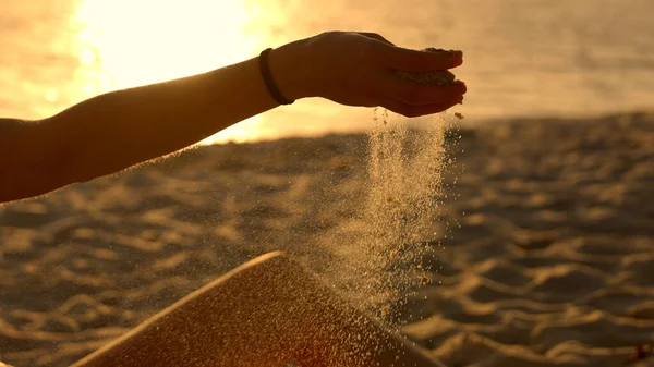 Jovem brincando com areia na praia ao pôr-do-sol - câmera lenta — Fotografia de Stock