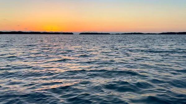 Красивый закат над спокойной водой океана — стоковое фото