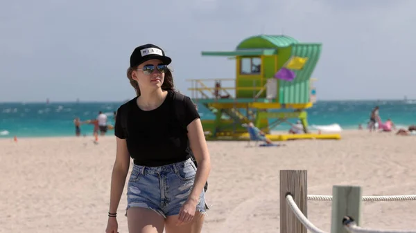 Güzel bir kadın güneşli bir günde Miami sahilinde yürür. — Stok fotoğraf
