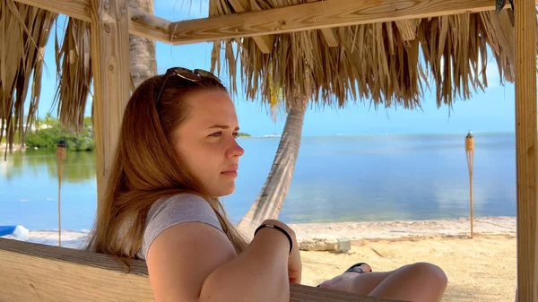 Paradise beach - Jonge vrouw zit op een bankje te genieten van de Caribische sfeer — Stockfoto