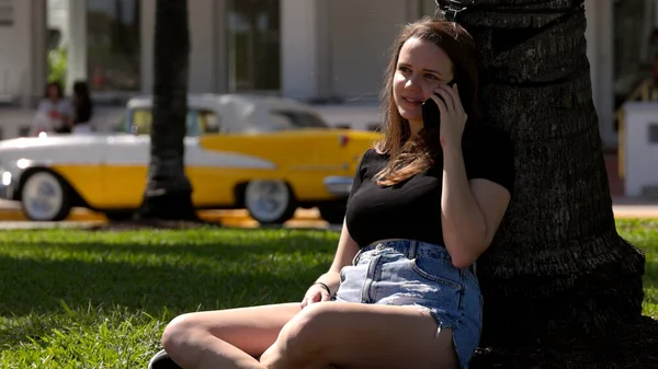 在阳光明媚的一天，年轻女子在迈阿密海滩的长廊放松了下来 — 图库照片