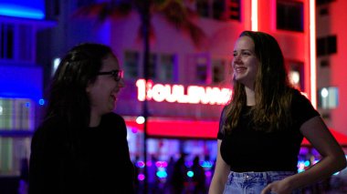 Gece Miami Plajı 'nda iki kız. Güney Sahili' nin renkli Okyanus Yolu.