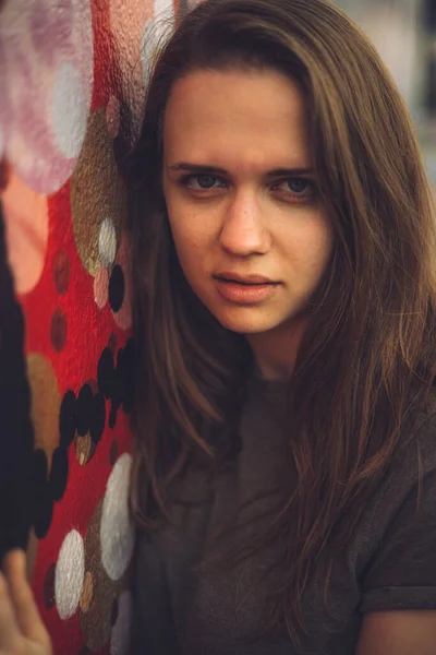 Ritratto di una bella ragazza per le strade contro un muro colorato - street style photography — Foto Stock