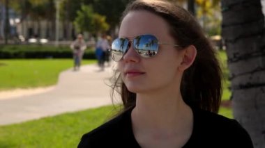 Genç ve güzel bir kadın Miami sahilinin güneşinin tadını çıkarıyor.