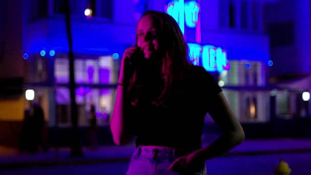 Kleurrijke Ocean Drive op Miami Beach 's nachts - Jonge vrouw neemt een telefoontje onder de neon lichten — Stockvideo