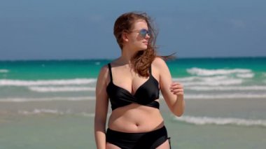 Rüzgarlı bir günde Miami Plajı 'nda bikini giyen genç ve güzel bir kadın.
