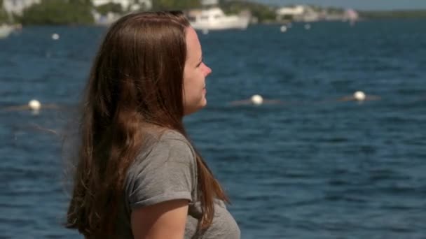 Schöne Frau sitzt auf einem Felsen am ruhigen Wasser der Florida Keys — Stockvideo