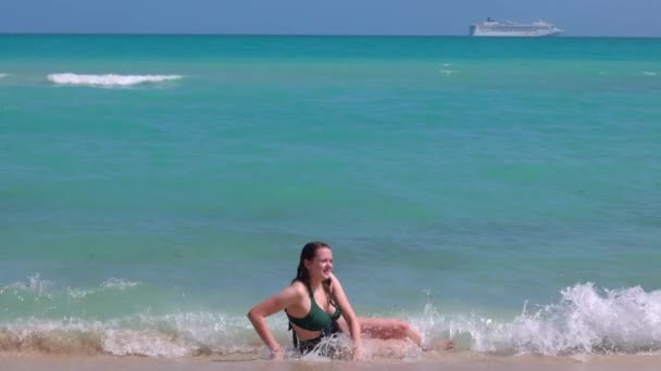 Gyönyörű nő fürdőruhában élvezi a kék óceán vizét Miami Beach-en. — Stock videók
