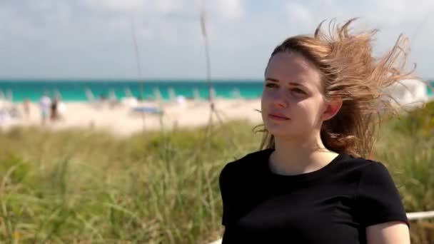Молодая женщина прогуливается по дюнам Майами-Бич — стоковое видео