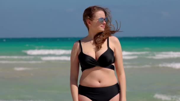 Joven mujer bonita usando un bikini en Miami Beach en un día ventoso — Vídeo de stock