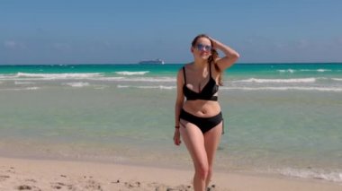 Genç bir kadın Miami Sahili 'nde güneşin tadını çıkarıyor.