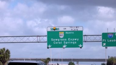 Florida otoyolundaki sokak tabelası Coral Springs ve Sawgrass Otoyolu 'nu gösteriyor.